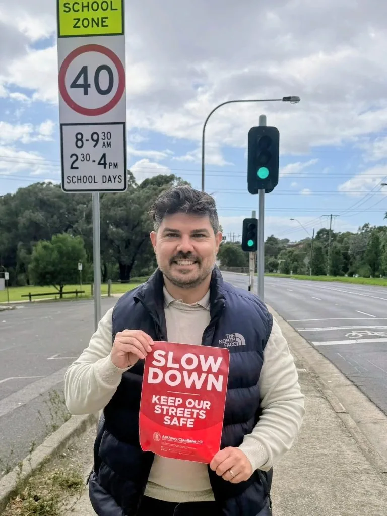 Anthony Cianflone with a Slow Down road-safety sign